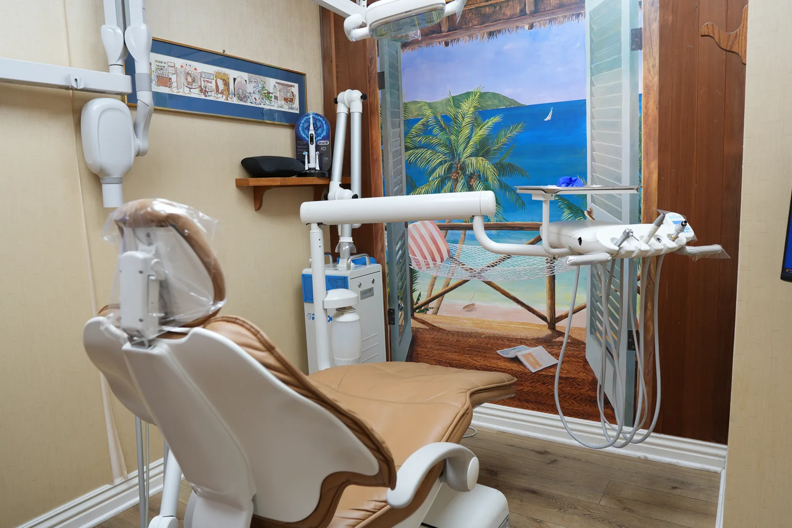 A treatment chair beneath the tropical mural
